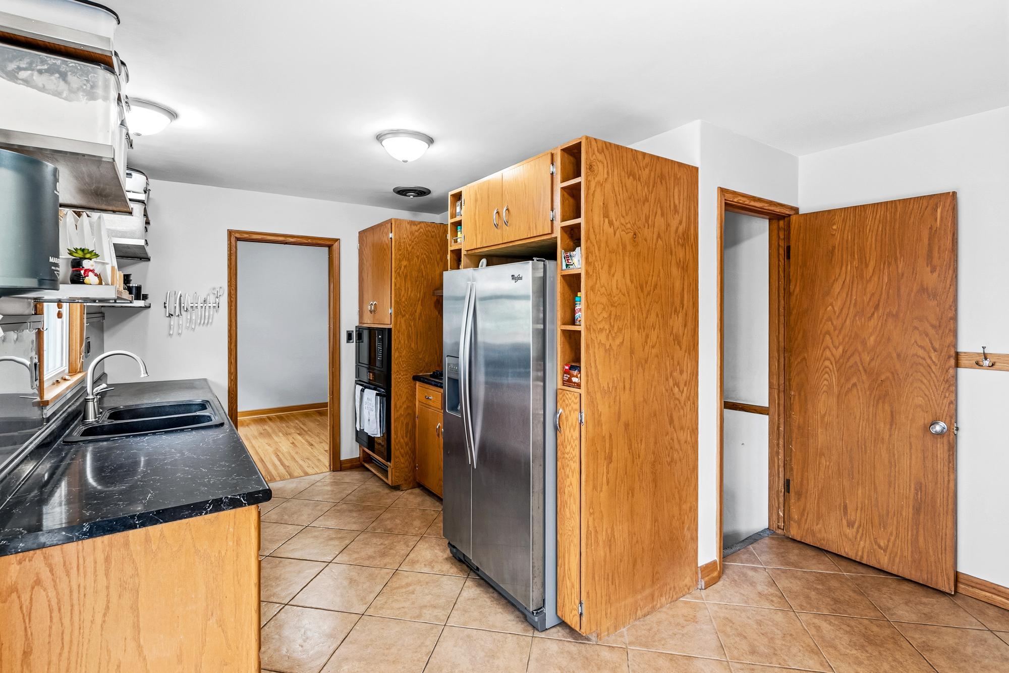 A view from the breakfast bar/eat in kitchen area to one of the first-floor bedrooms (could also be used as an office or playroom) and door to the lower level