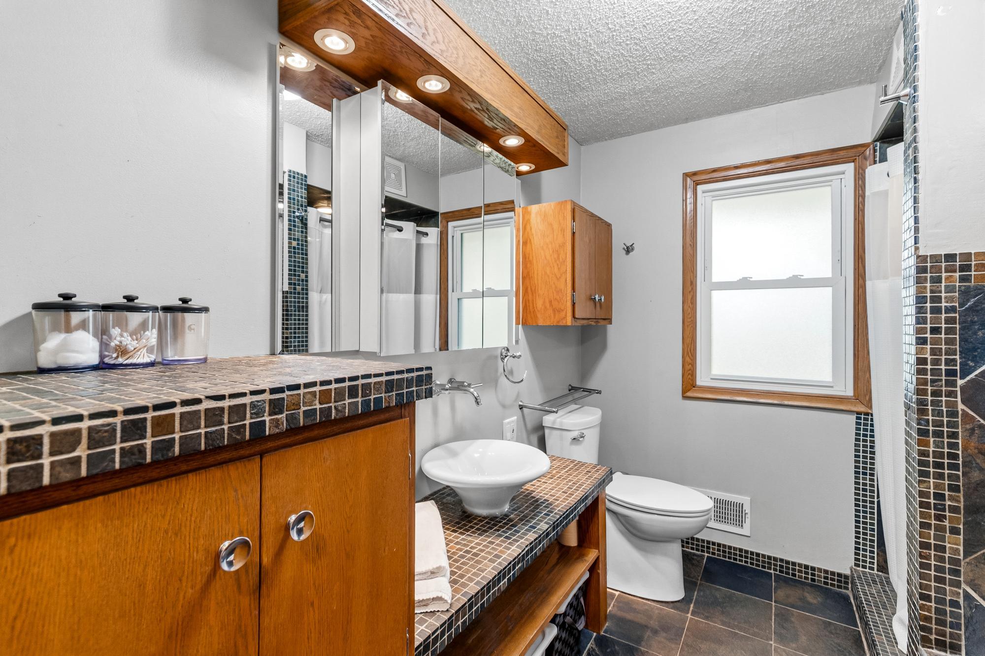 Main floor full bathroom shows off its stunning tile work