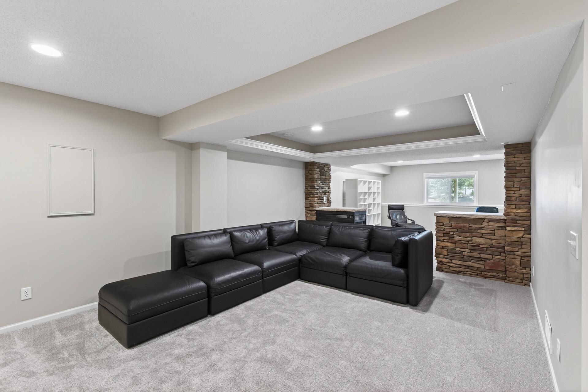 Finished lower level features a cozy second fireplace, custom built-ins and a wet bar.