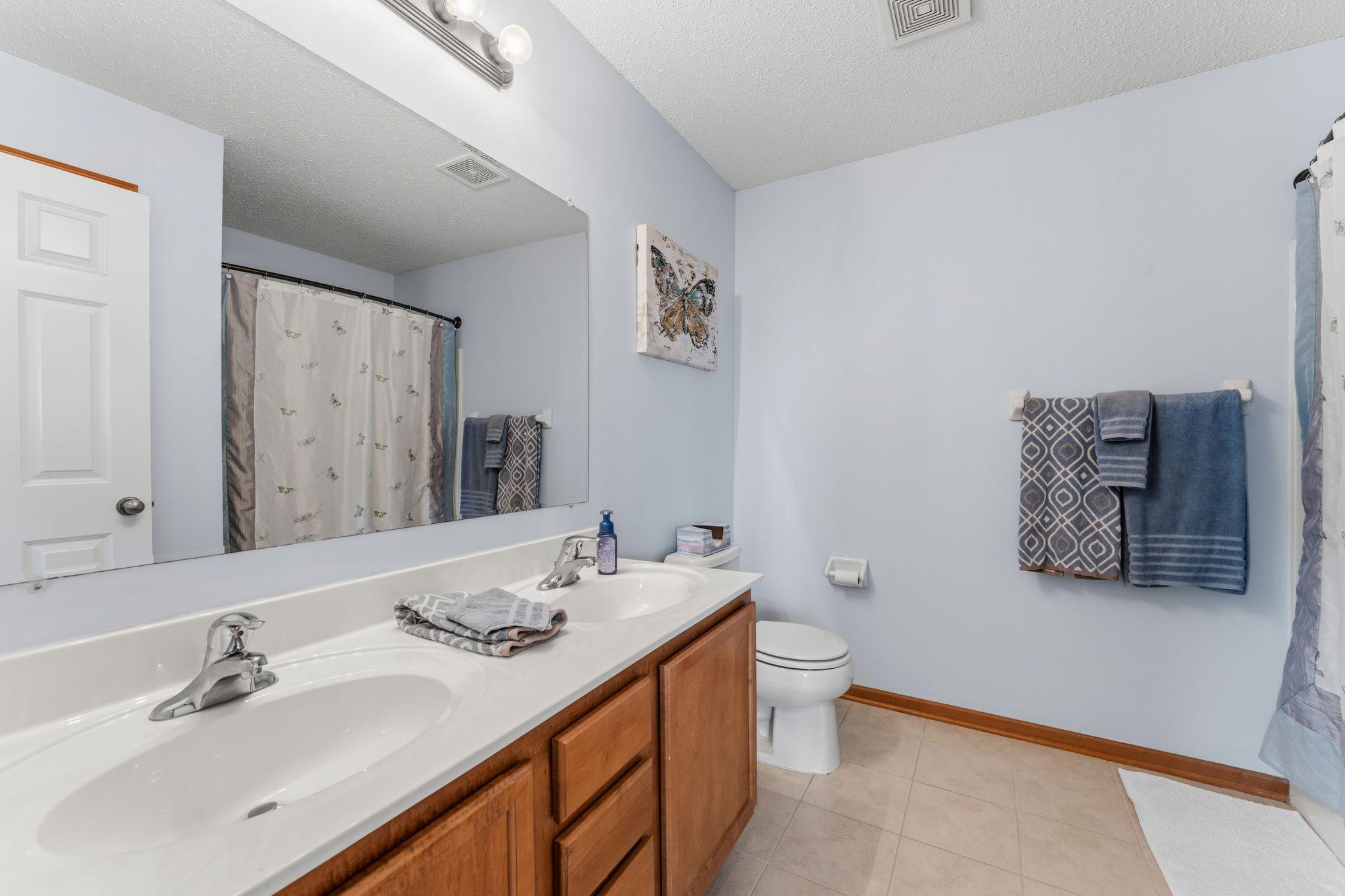 Full bathroom with double vanity, ample counter space, and clean, functional design.