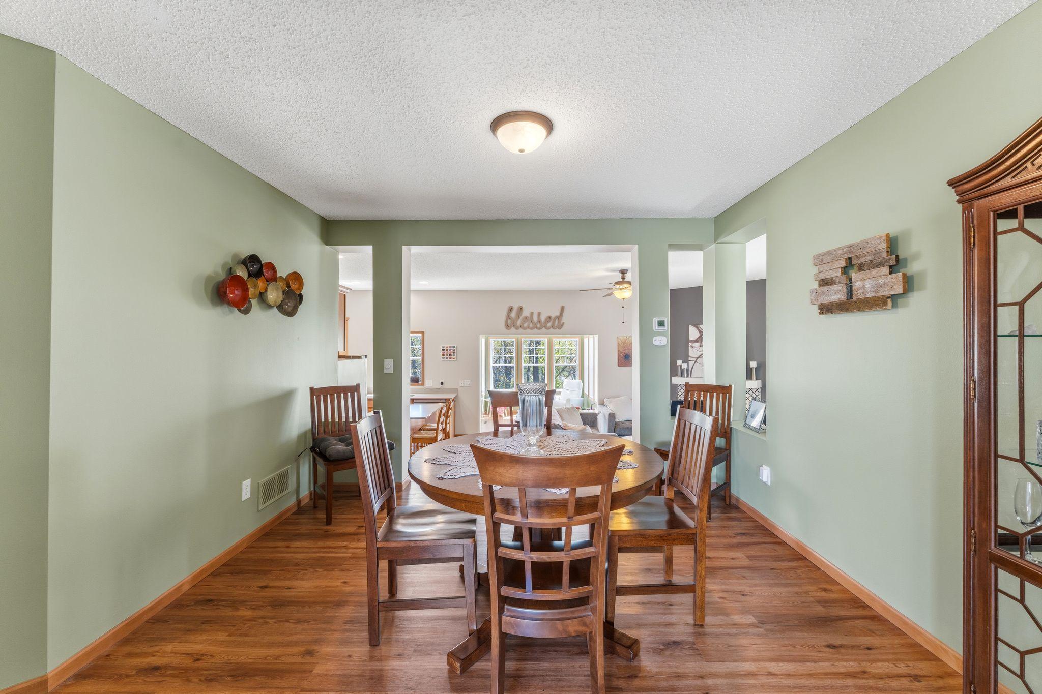 Dedicated dining room with warm flooring and an open view into the main living space, perfect for everyday meals or hosting.