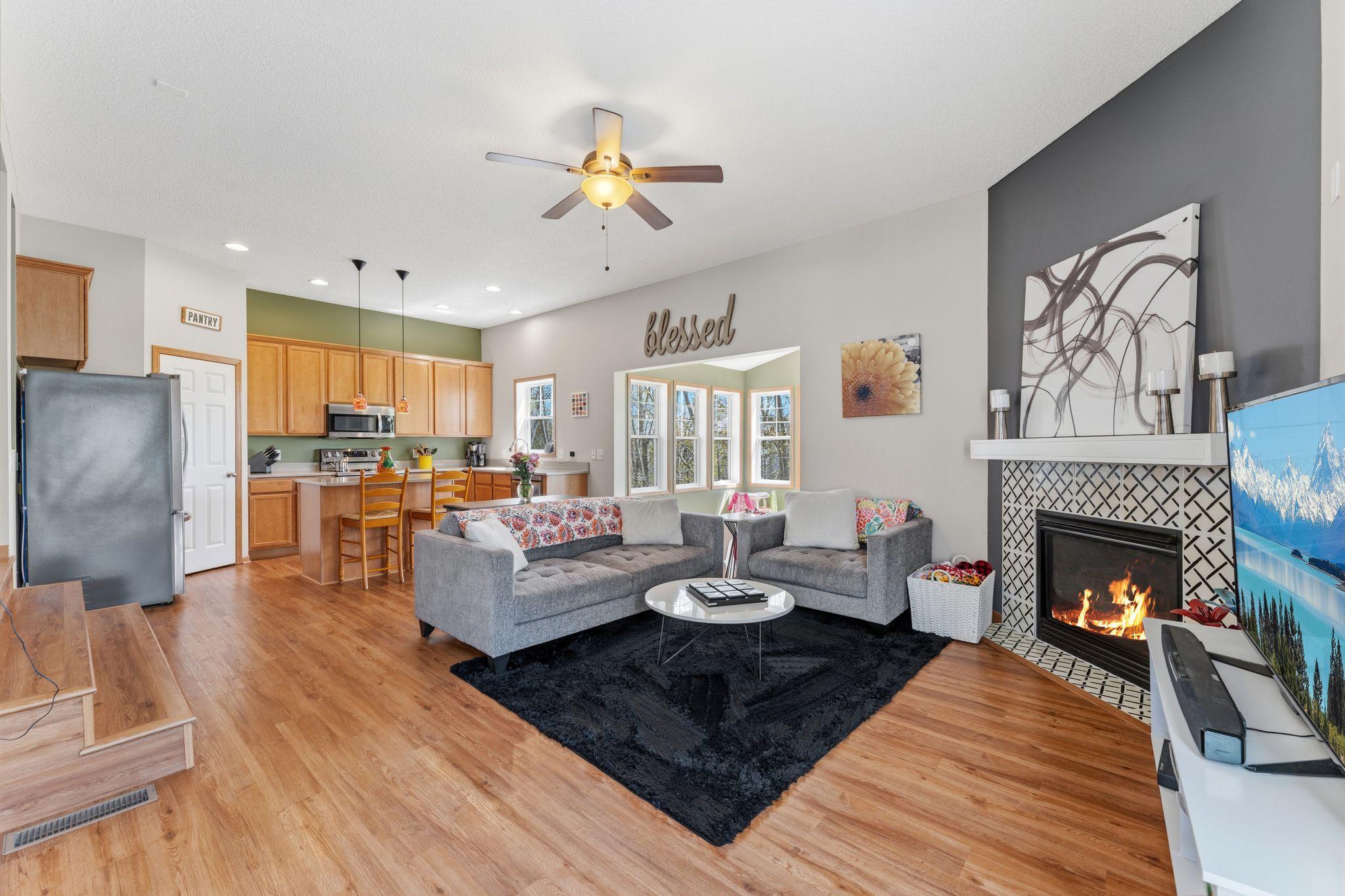 Open-concept main level with spacious living area, cozy gas fireplace, and seamless flow to the kitchen