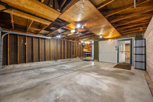 Attached 2 Car Garage with Gardening Space Tucked in the Corner And Additional Entrance Walking out to the Patio