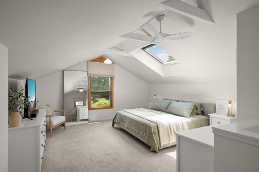 Tons of space in this upper level primary suite offering dramatic ceilings.