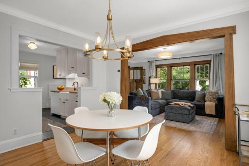 Dining room that is open to kitchen and framed opening in wood surround that leads to living room.