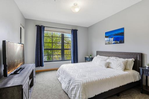Primary bedroom featuring a large window that fills the space with natural light, creating a bright and airy retreat with a warm, inviting atmosphere.
