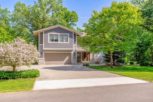 Stunning curb appeal highlighted by mature trees, manicured landscaping, and an inviting front entry.