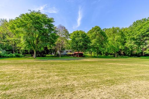 Exceptional lot showcases a sprawling lawn, mature trees, and a private park-like setting perfect for outdoor enjoyment.