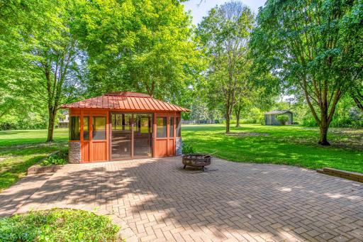 The backyard blends natural beauty and functional outdoor living with mature trees and inviting gathering spaces.