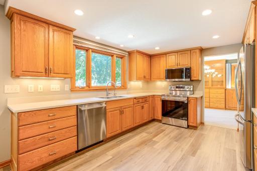 Enjoy meal prep with a view in this inviting kitchen, highlighted by large windows, ample workspace, and warm wood cabinetry throughout.