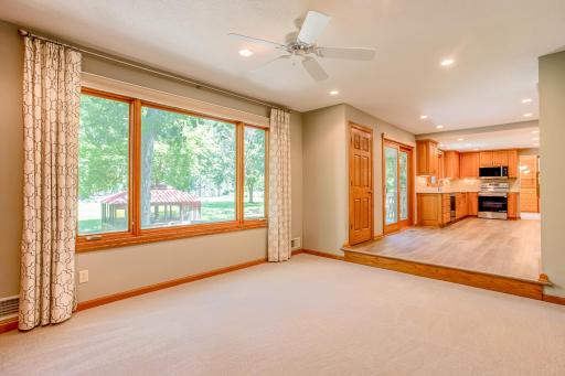 Large picture windows fill the family room with natural light while showcasing beautiful views of the mature, tree-lined property.