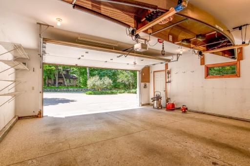 Spacious attached garage with room for vehicles, recreational equipment, and additional storage, plus convenient built-in shelving.