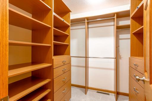 Well-appointed walk-in closet with built-in shelving, drawers, and abundant hanging space to keep everything neatly organized.