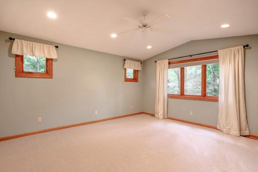 Inviting primary bedroom retreat featuring soft natural light, vaulted ceilings, and serene views that create a peaceful atmosphere.