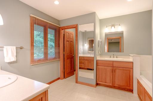 Spacious ensuite bathroom featuring dual vanities, abundant storage, and a bright, open layout designed for everyday convenience.