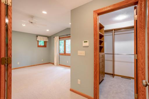 Spacious primary suite with vaulted ceilings, large windows, and a generous walk-in closet designed for effortless organization.