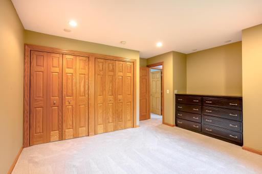 Well-sized bedroom with generous closet space, a drawer nook, and warm wood trim throughout.