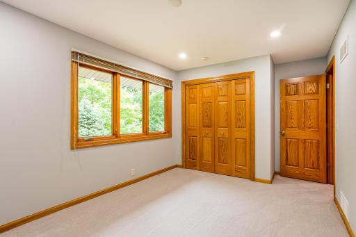Inviting bedroom featuring a spacious closet, neutral finishes, and tranquil views of the surrounding landscape.