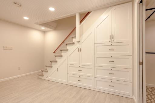 Custom built-in storage beneath the staircase maximizes space with beautifully crafted cabinetry, offering exceptional organization and functionality.