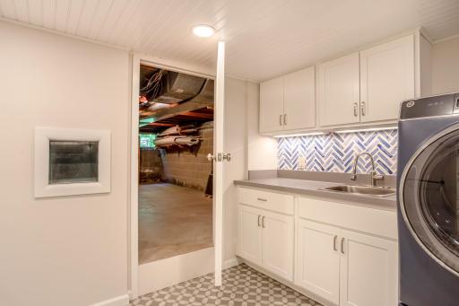 Functional laundry and utility space offers ample storage, workspace, and easy access to additional basement storage areas.