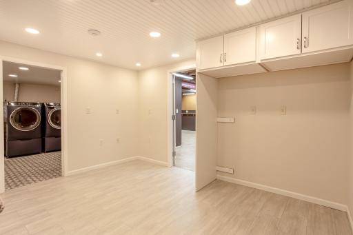 Flexible lower-level hobby room with durable flooring, recessed lighting, and built-in cabinetryâideal for hobbies, crafts, a home office, or additional living space.
