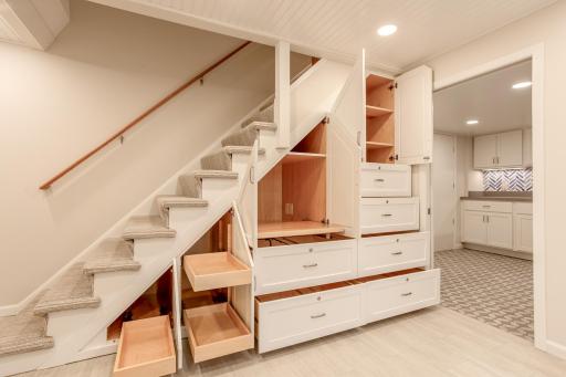 Thoughtfully designed under-stair storage features an impressive combination of drawers, cabinets, and workspace solutions, creating a highly efficient and versatile area.