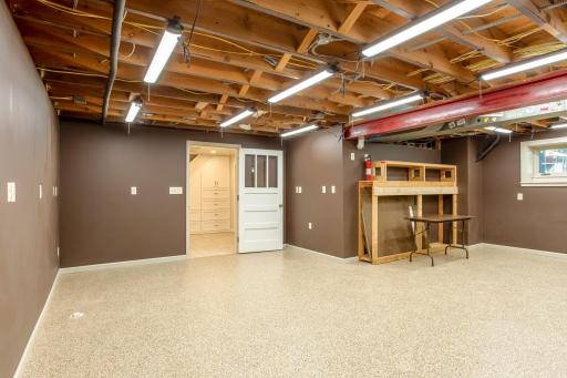 Versatile lower-level workshop features durable flooring, ample electrical access, and flexible space to accommodate a variety of uses.