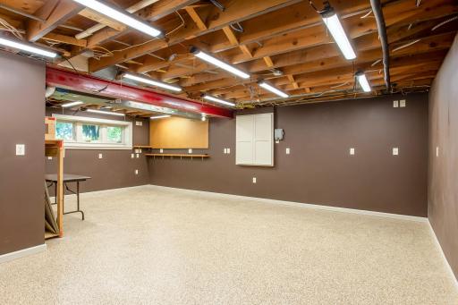 Large workshop area offers abundant room for projects, hobbies, or creative pursuits, complete with built-in work surfaces and excellent lighting.