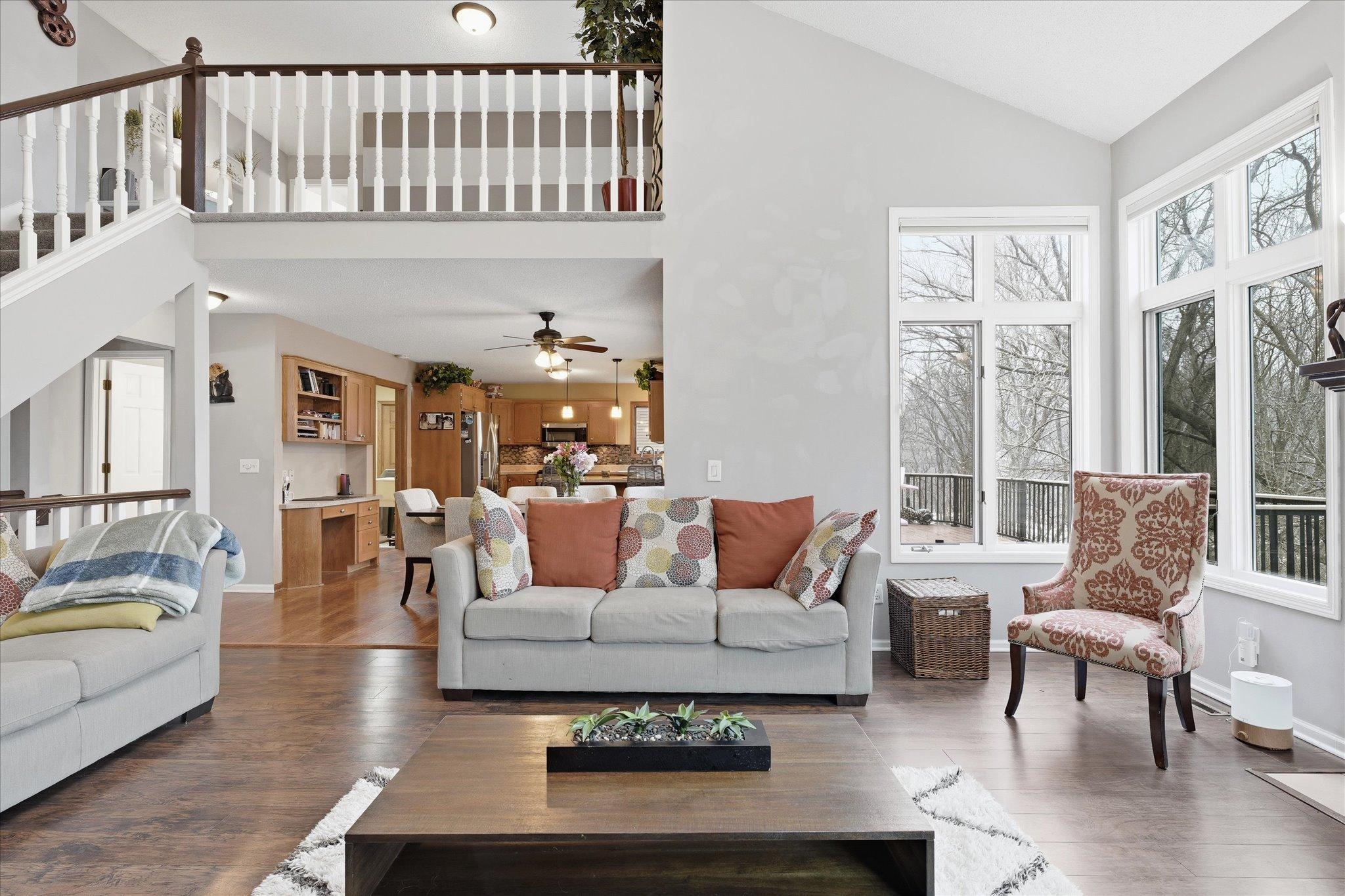 Bright and open great room with expansive windows, wood-look floors, and classic white trim for a fresh, modern feel.