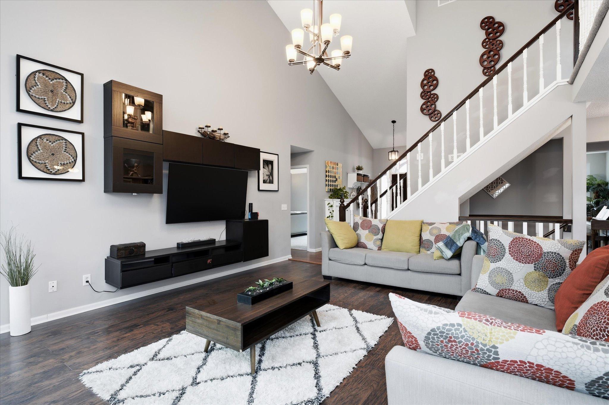 Enjoy this airy great room, complete with high ceilings, light-filled windows, and timeless flooring