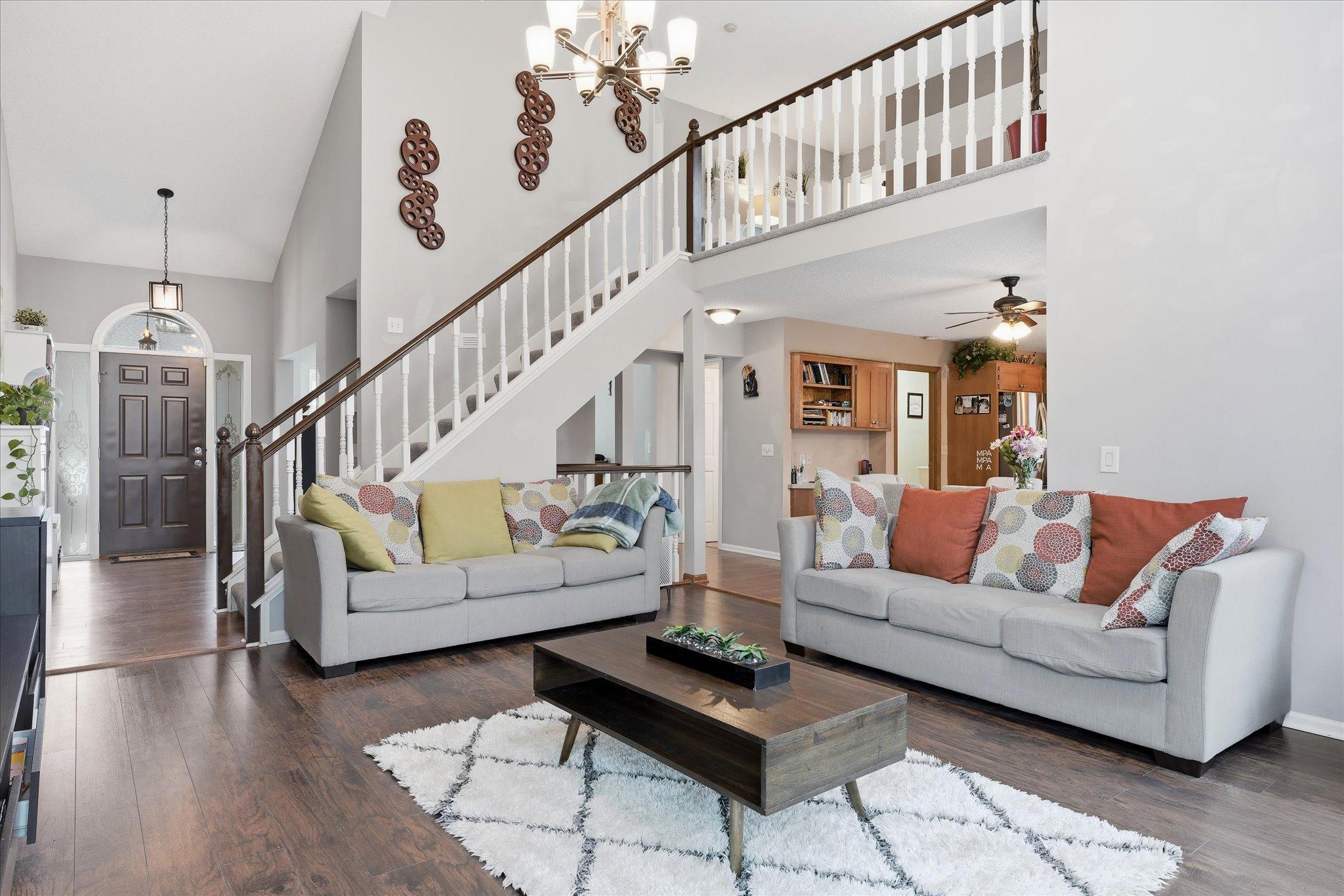 Spacious and inviting great room with soaring ceilings, neutral palette.