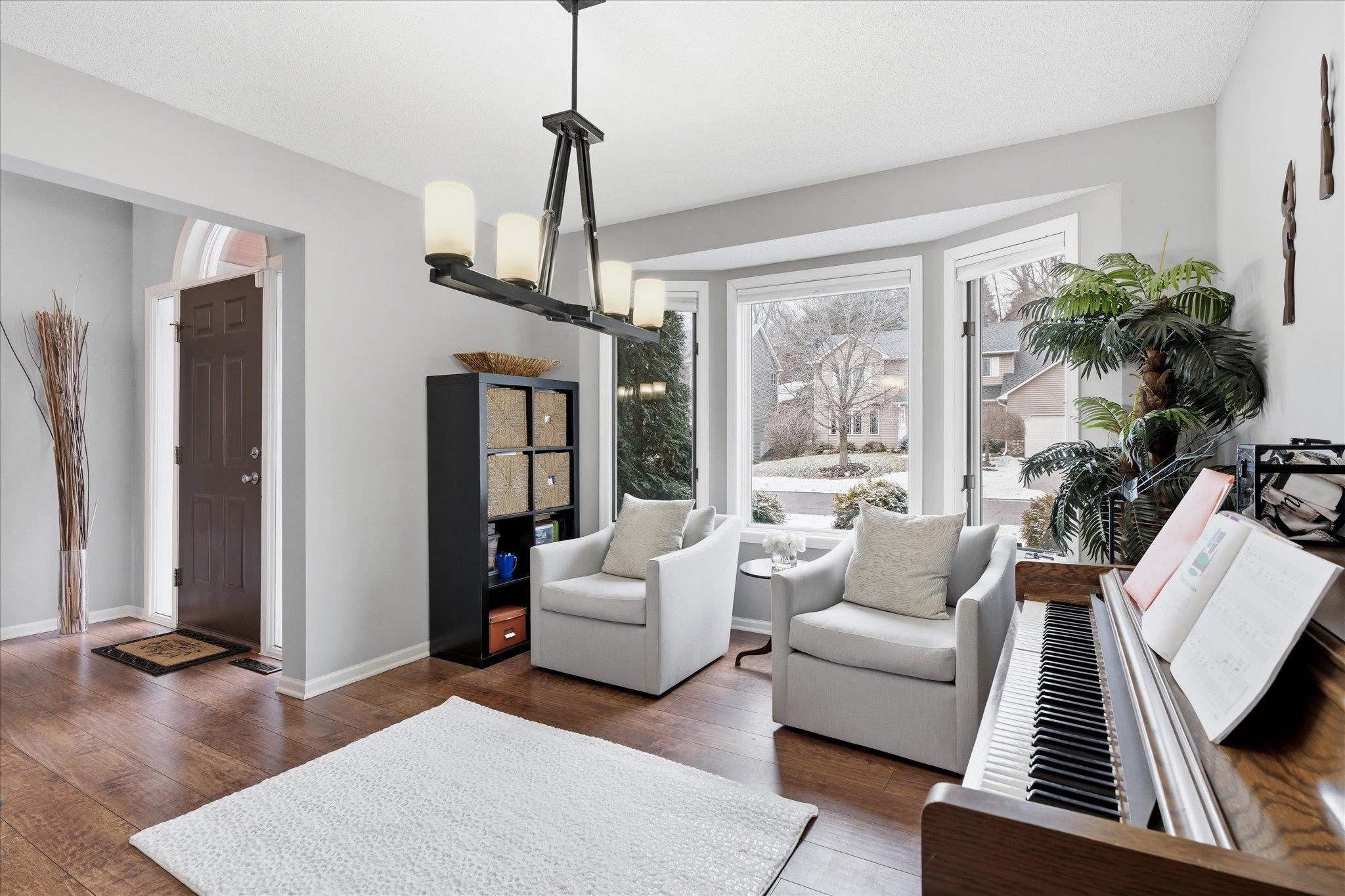Bright and adaptable room featuring a bay window, classic white trim, ideal for entertaining, working from home, or relaxing with music.