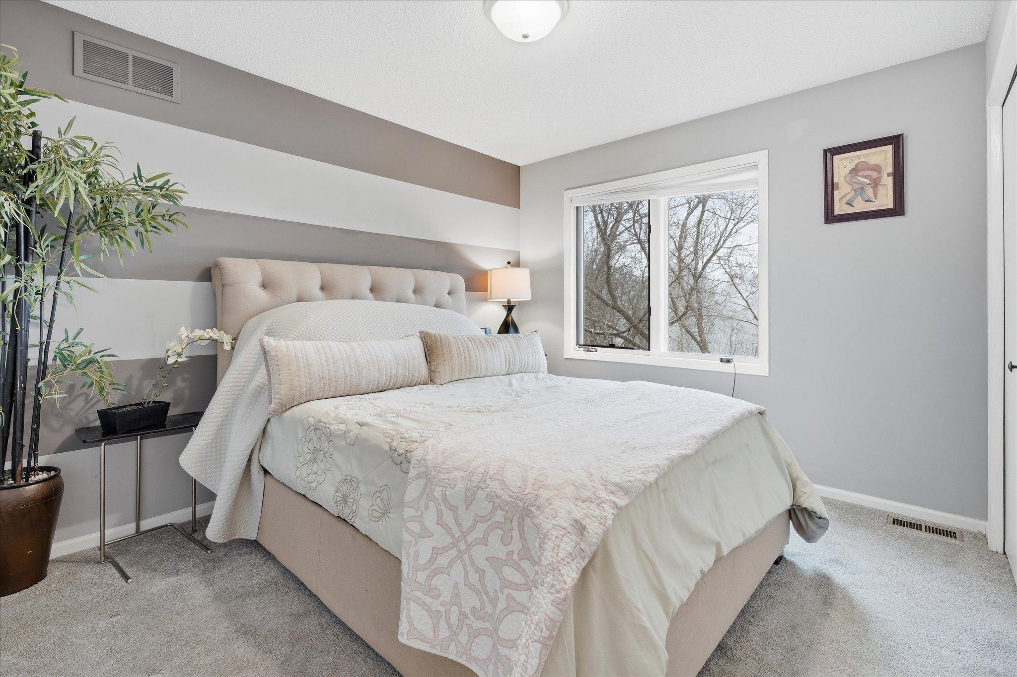 Bright upper-level bedroom featuring newer flooring, neutral tones, and ample space