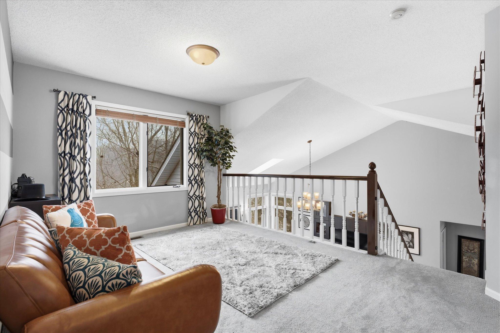 Open loft overlooking the great room with views of the backyard—ideal as a home office, lounge, or play area.