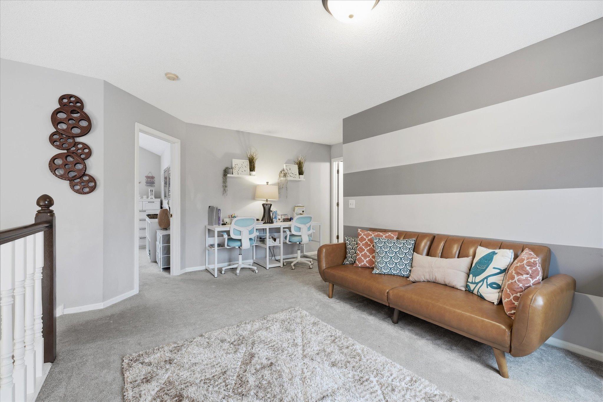 Flexible loft space with scenic backyard views and open design, perfect for working, relaxing, or entertaining.