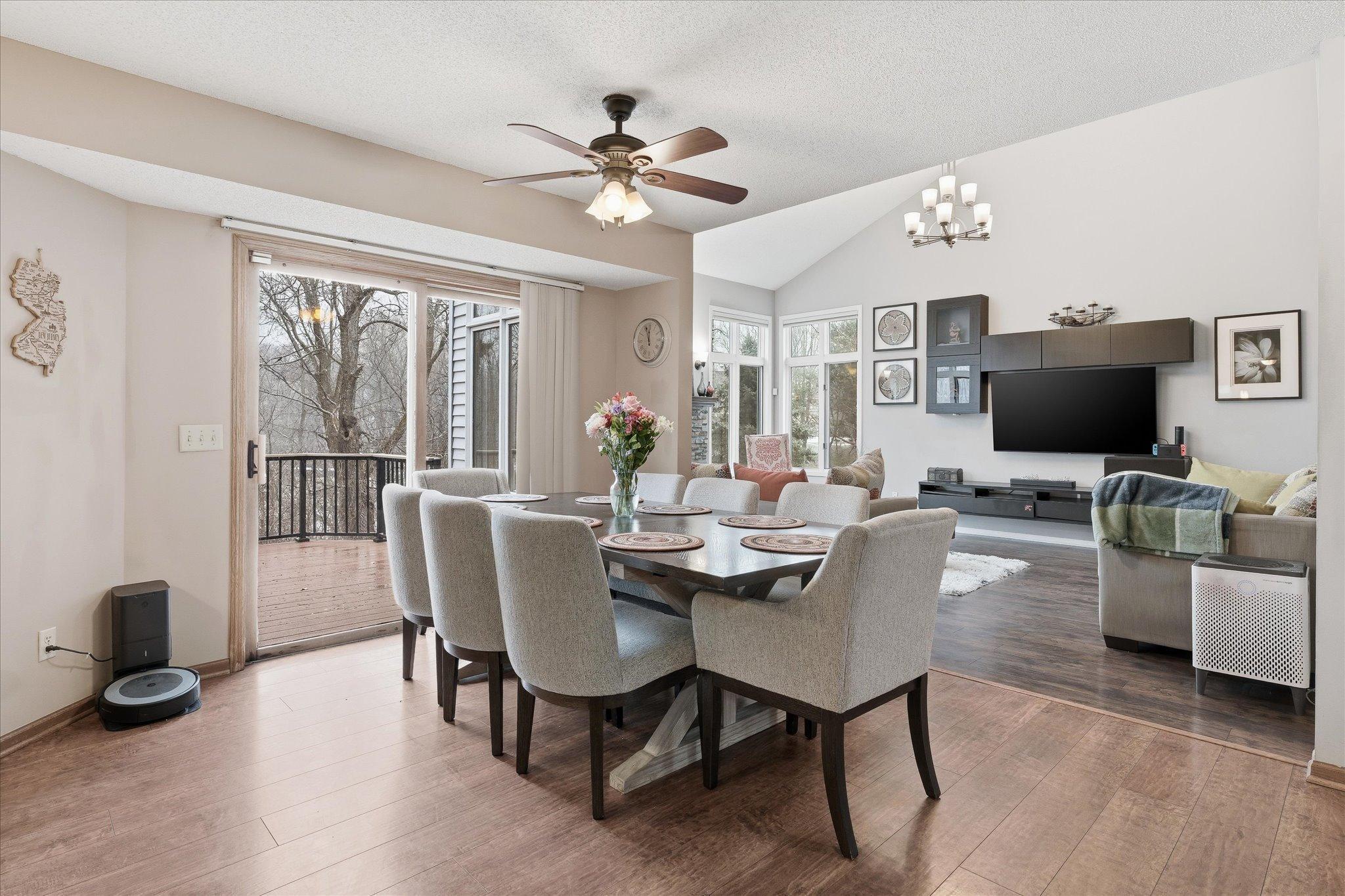 Bright informal dining area with sliding glass doors to the backyard deck, beautiful views of the wooded yard, and an open layout connecting to the kitchen and great room.
