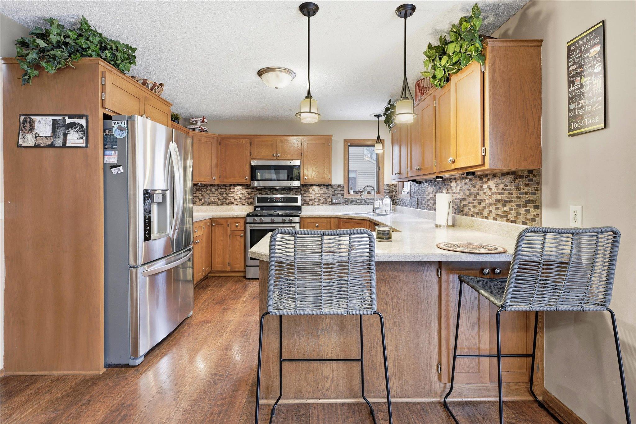 Functional and inviting kitchen with plenty of storage, a corner window for natural light, and open flow to the informal dining area and garage entrance.