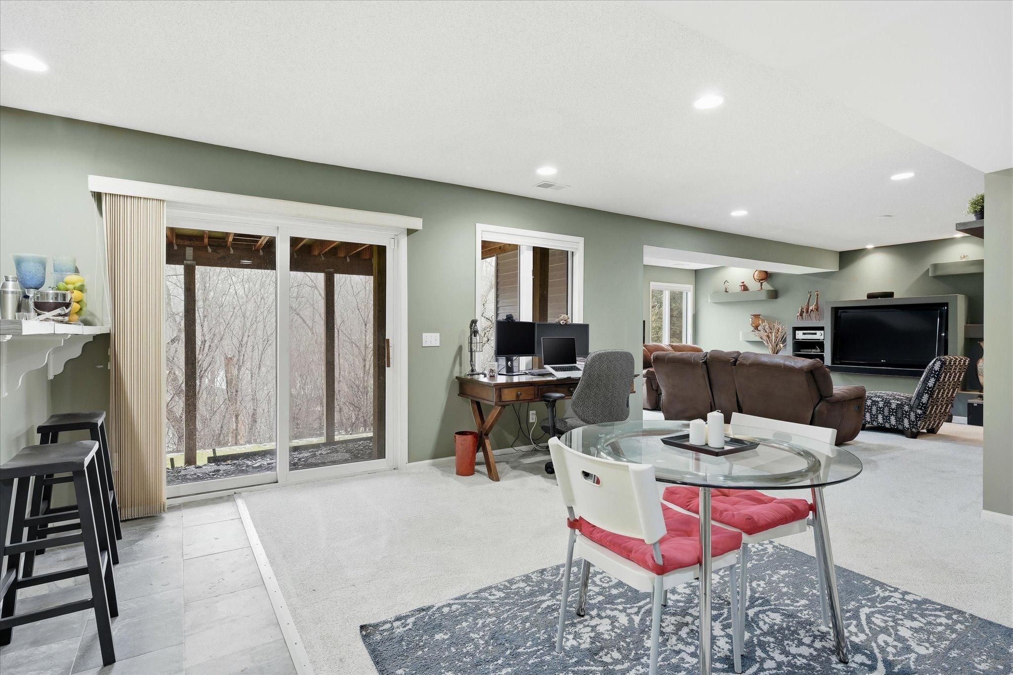 Fun-filled amusement room with a sliding glass door to the backyard, a bar, and a storage closet for games—perfect for entertaining and family activities.