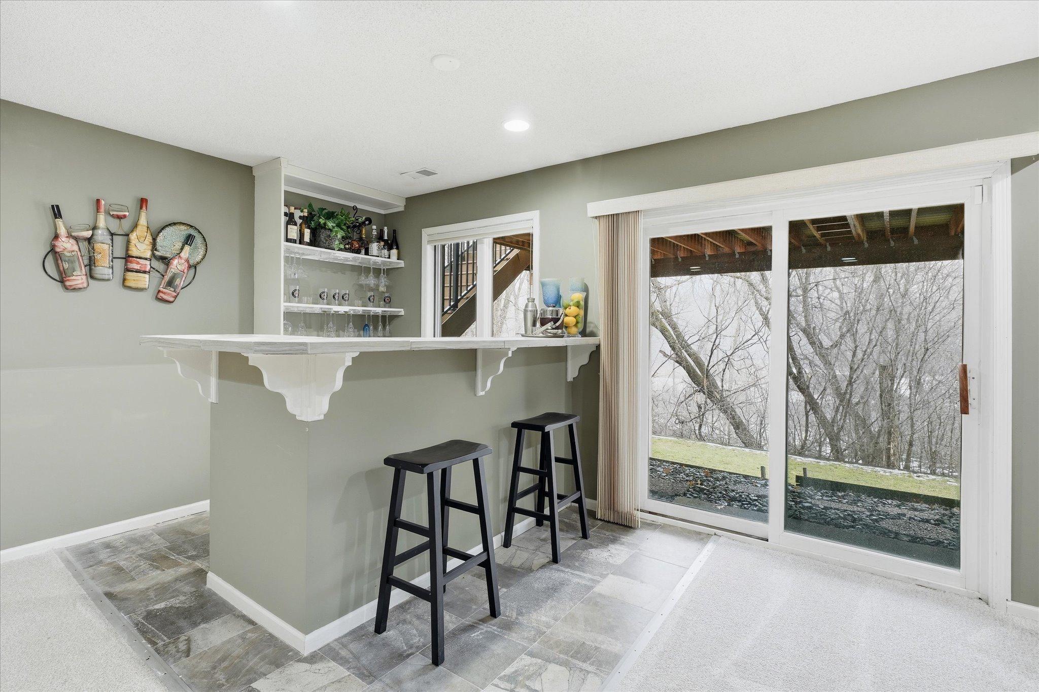 Entertainer’s dream space featuring access to the backyard, a bar, storage closet with ample storage for board games, and plenty of room for friends, fun, and family gatherings.