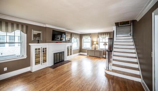 Living room with built in bookcases, solid hardwood floor & lots of windows to bring in the light