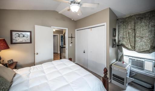 Another view of the primary bedroom with vaulted ceiling & ceiling fan
