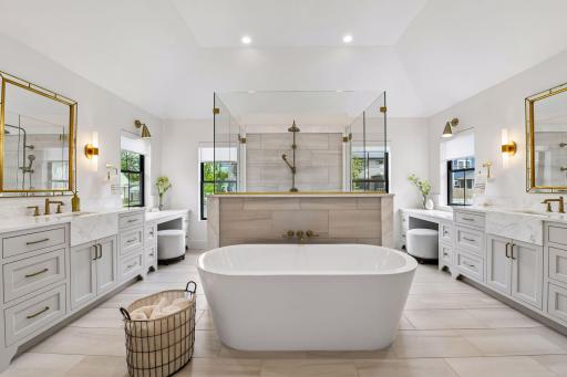 Primary bathroom retreat features in floor heat, free standing soaking tub and walk through tiled shower
