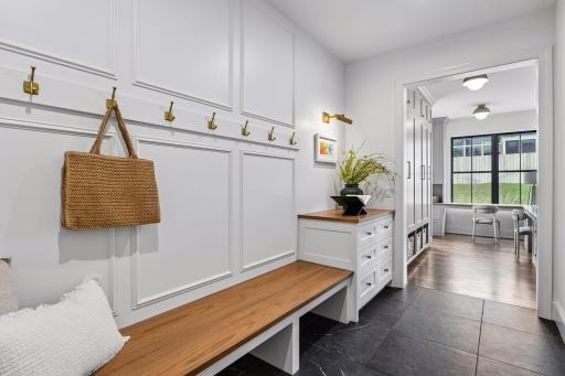Mudroom right off the garage features oversized built in bench and dedicated drop zone