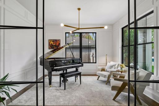 Front office space with floor to ceiling glass panels, custom lighting is perfect for a home office or formal seating