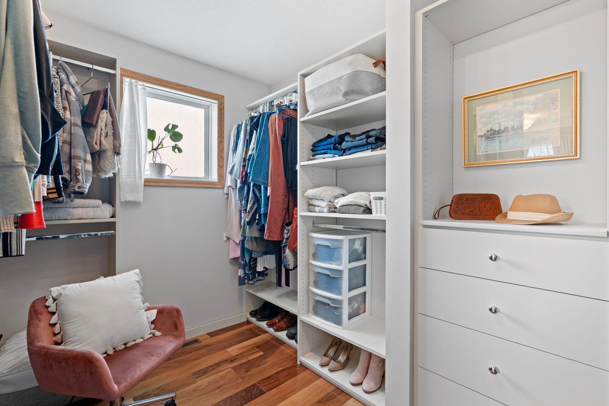 Primary bedroom with a large walk-in closet complete with built-ins and a window for natural light.