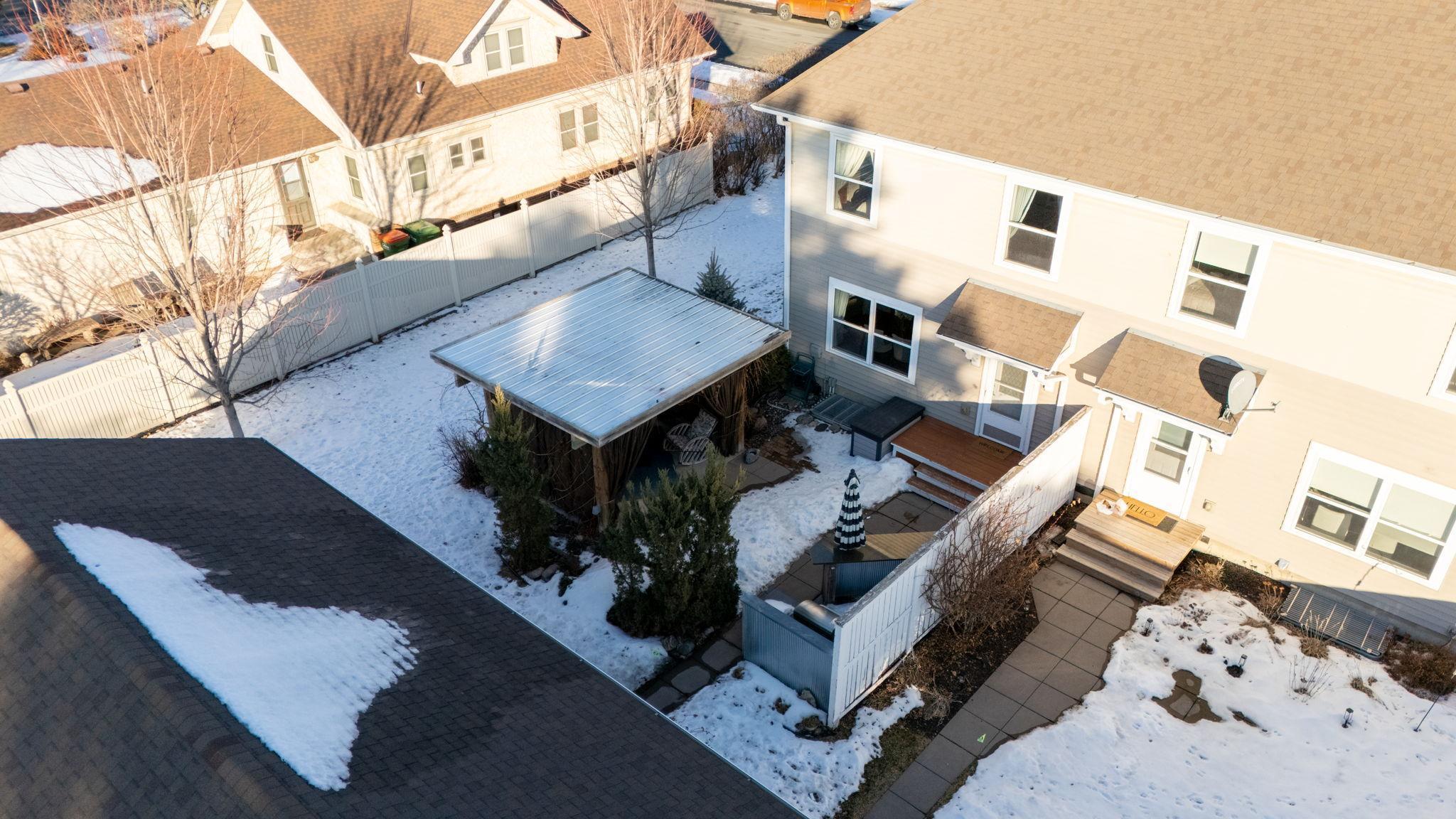 The private patio/cabana has a built in grill area and is surrounded by green space and established plantings—ideal for relaxing or entertaining.