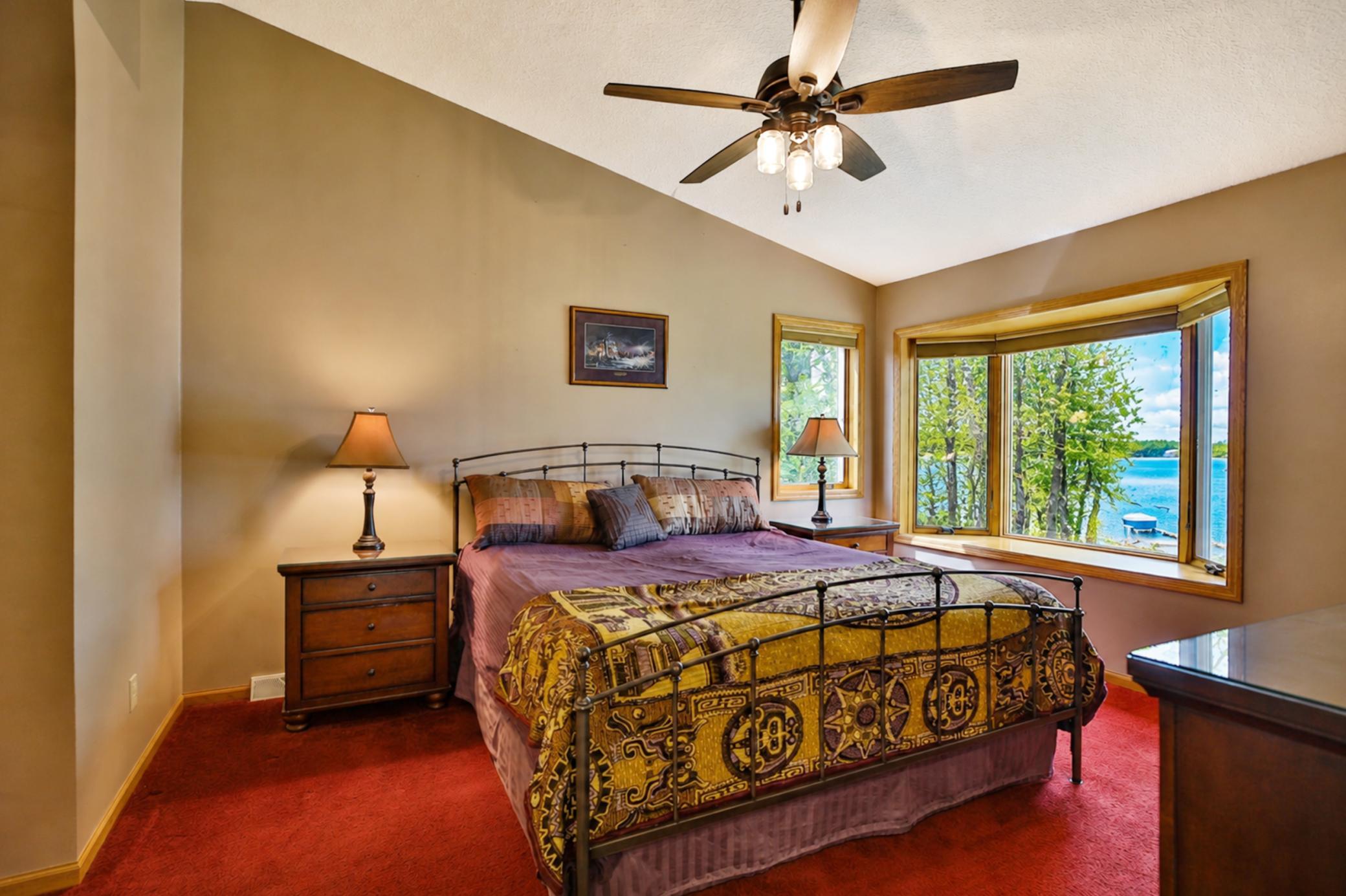 Spacious primary bedroom with large bay window with views of lake