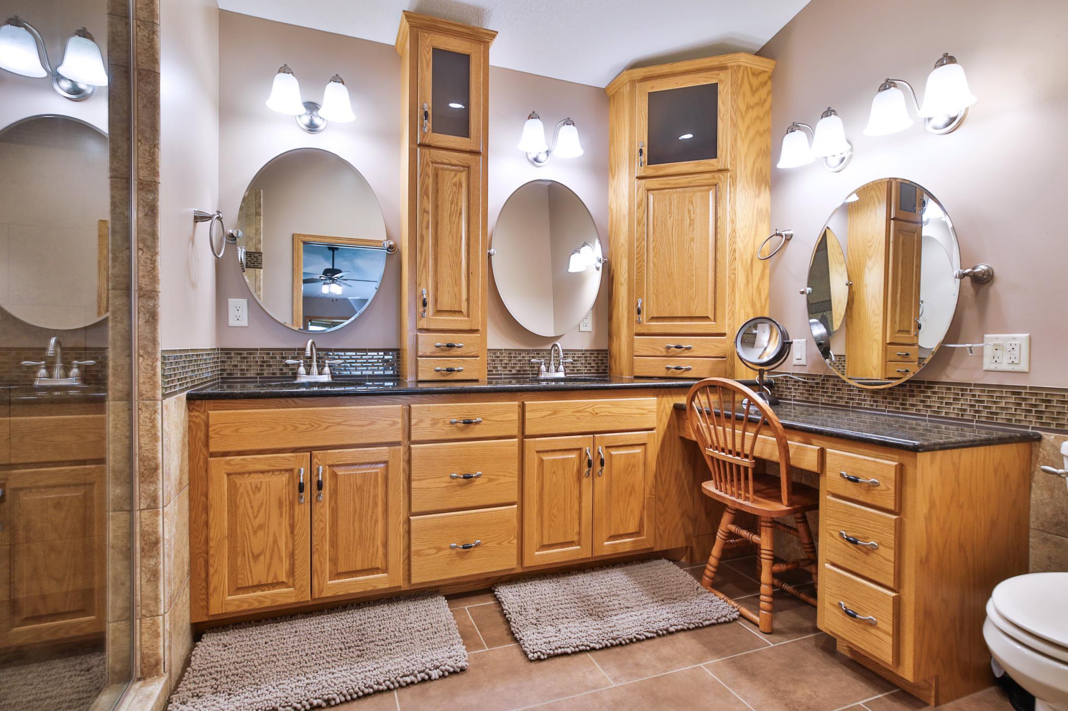 Primary bathroom with two separate sink areas and a separate makeup seating area