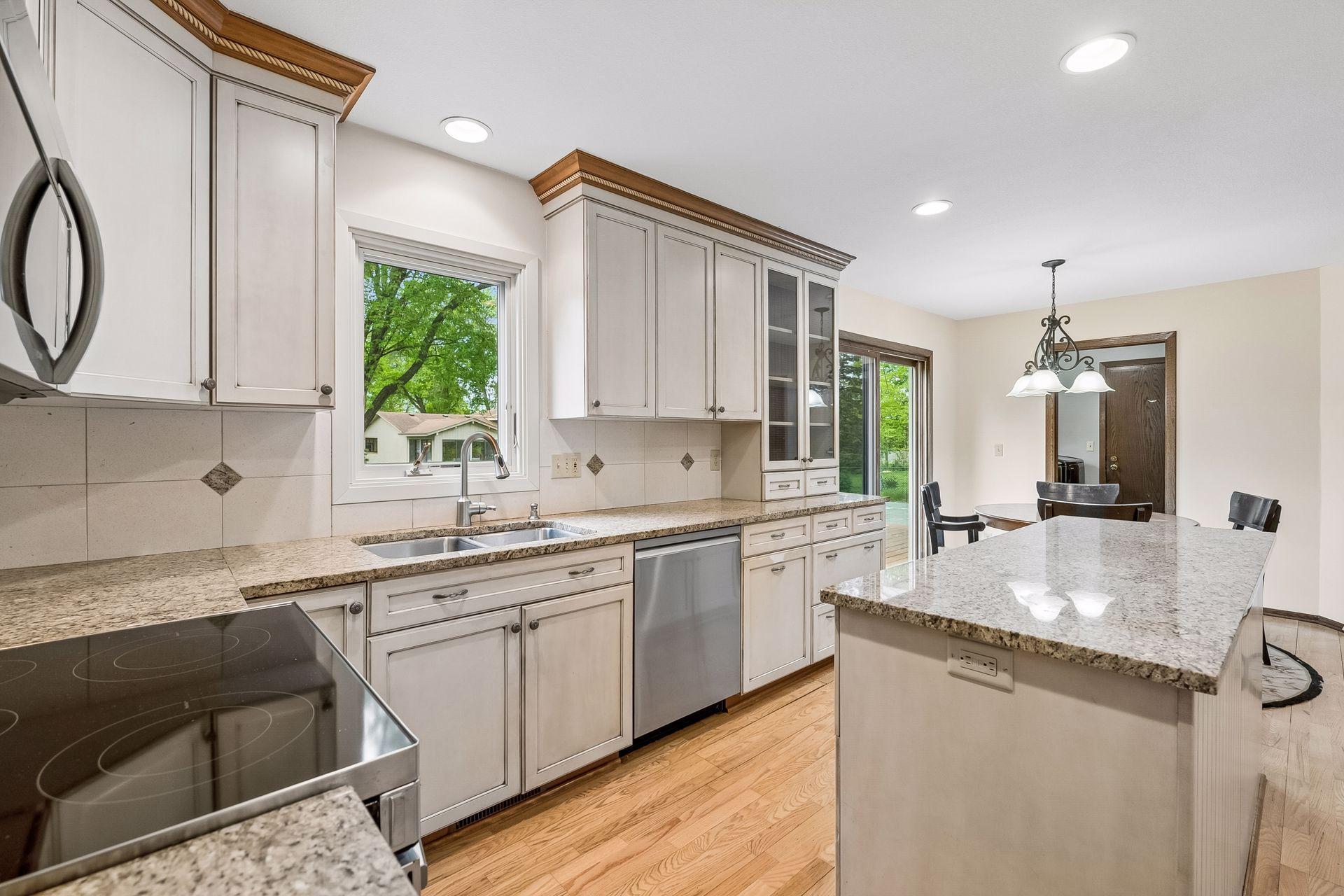 Kitchen with new stainless steel appliance, granite countertops and tile backsplash
