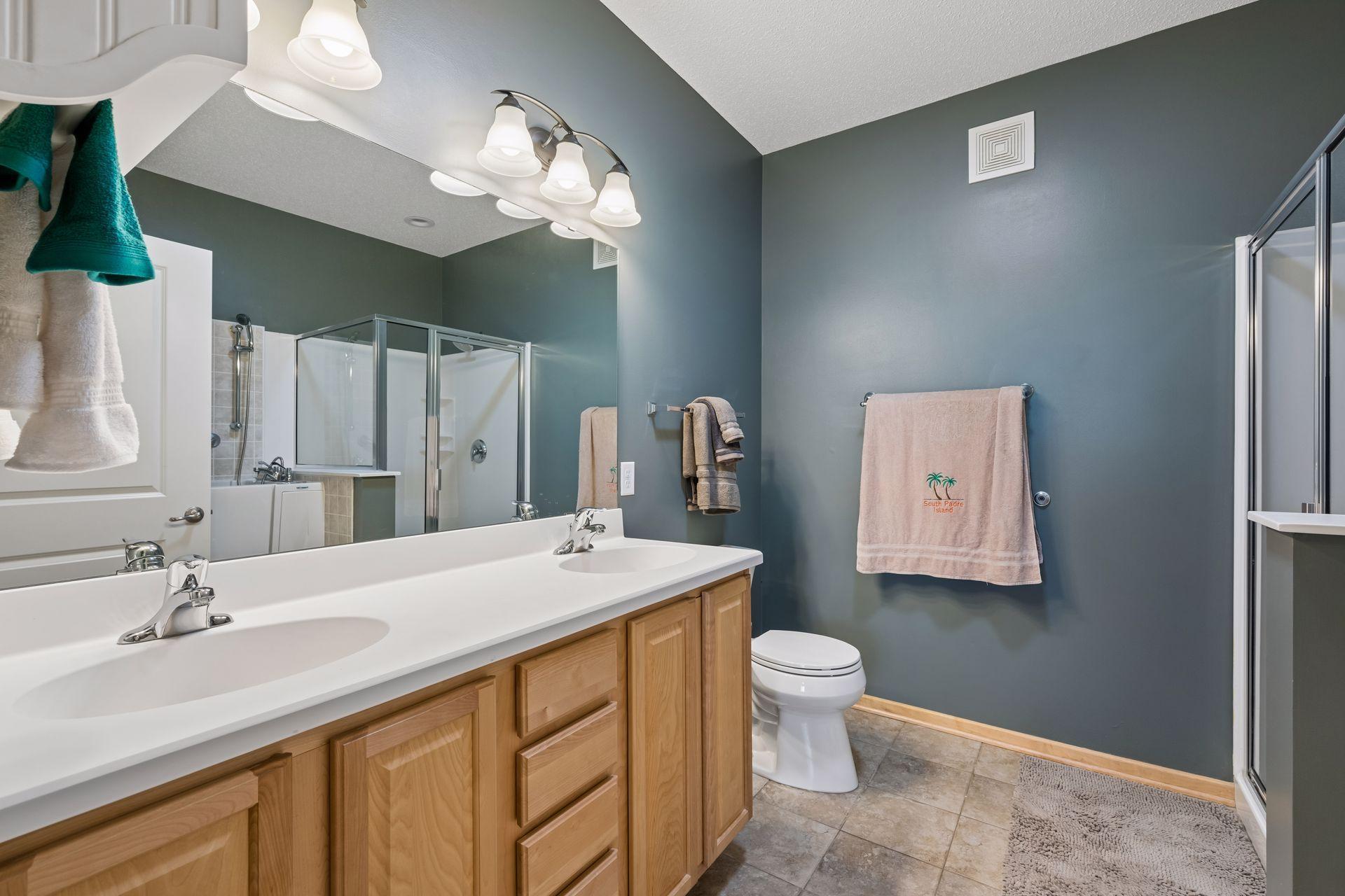 Primary bath features double sinks, ceramic tile and separate shower.